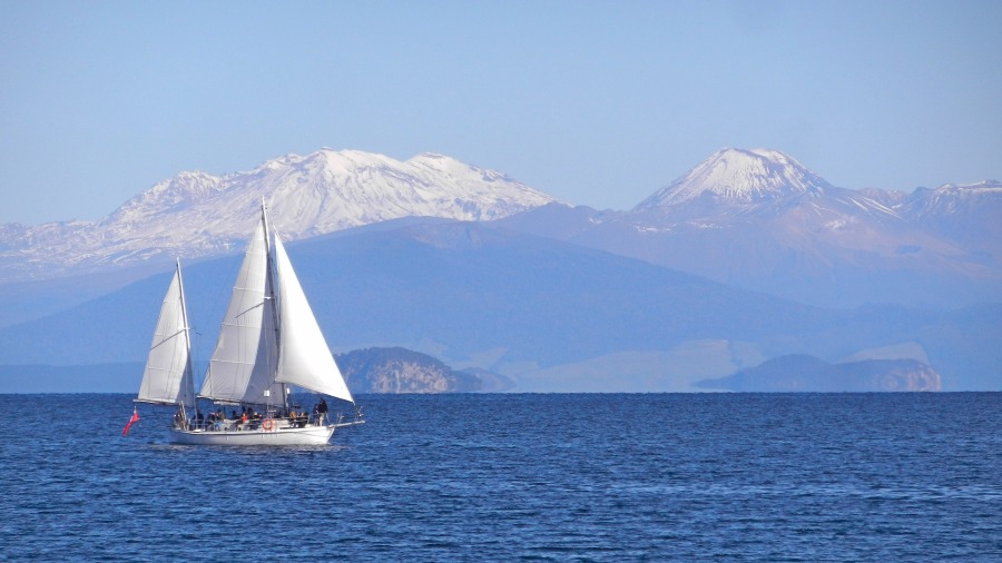 See mit Segelboot und im Hintergrund Bergkulisse